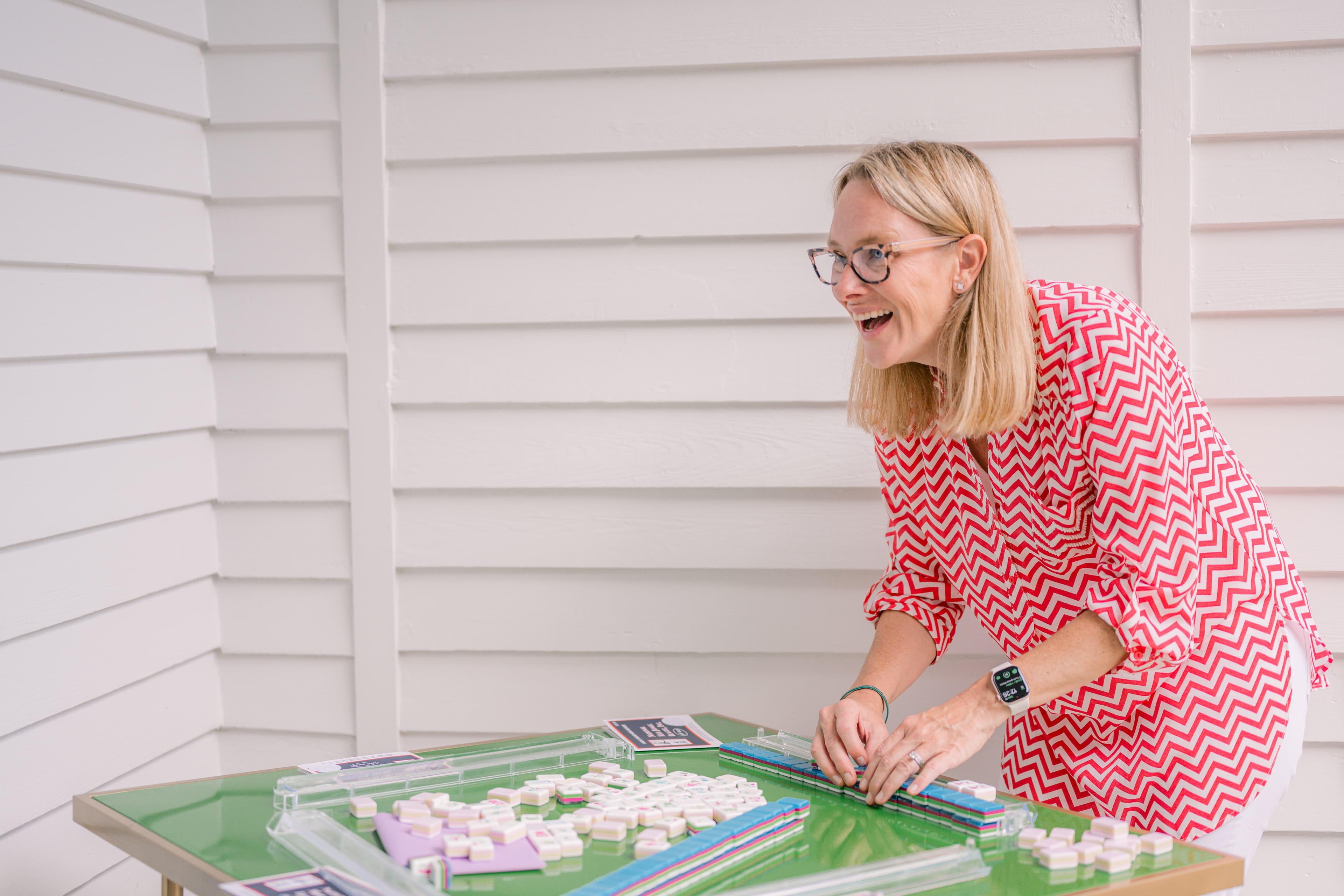 Woman smiling while playing Mahjong with Bam Good Time tiles