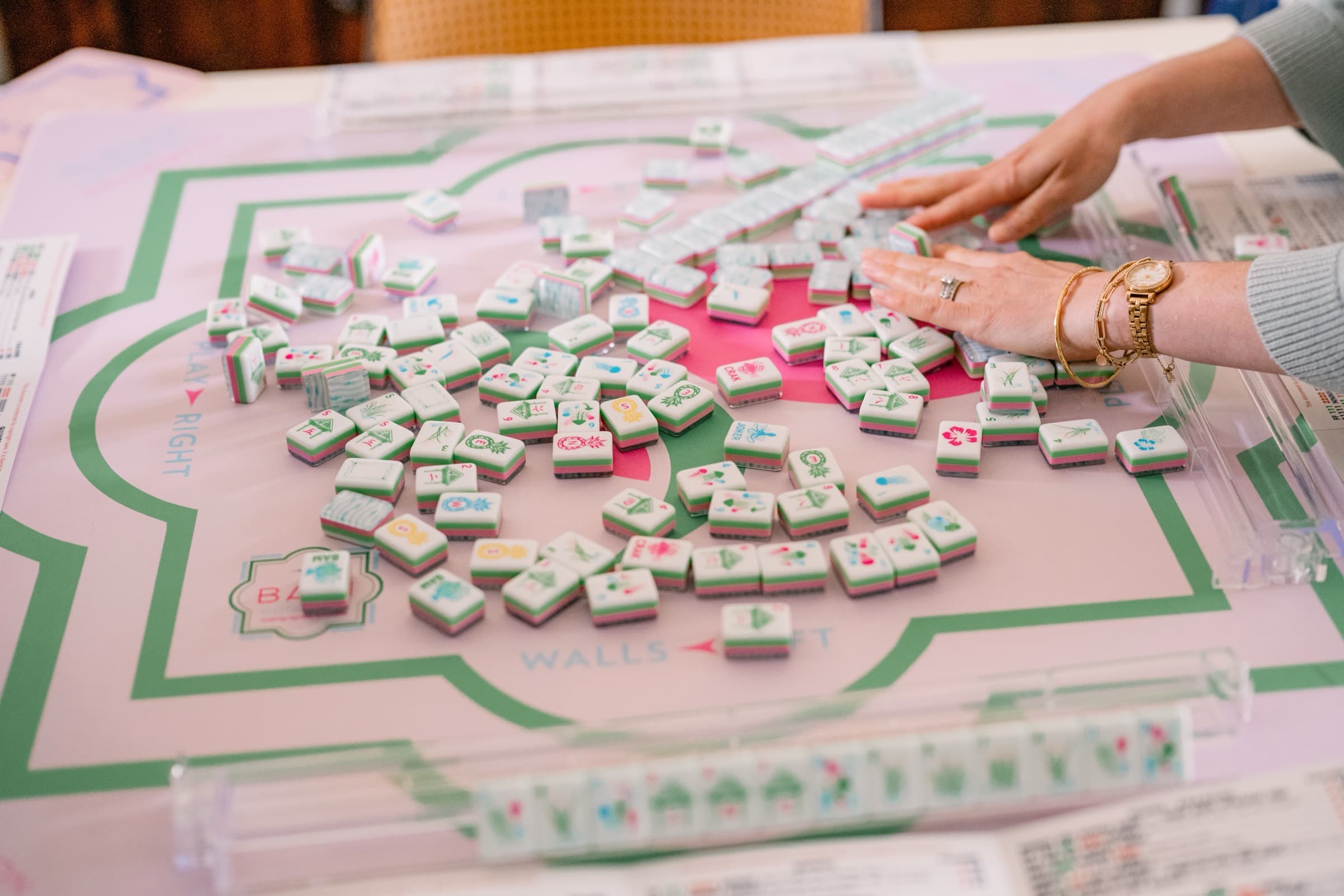 Mahjong tiles scattered on a BGT mat mid-game